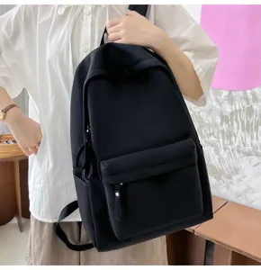 Detailaufnahme eines minimalistischen schwarzen Rucksacks aus Segeltuch an einem Model.