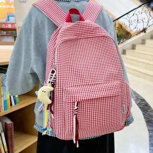 Red plaid backpack with cute star pendant on a student's back