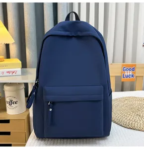 Vorderansicht eines minimalistischen tiefblauen Rucksacks auf einem Bettdeko.