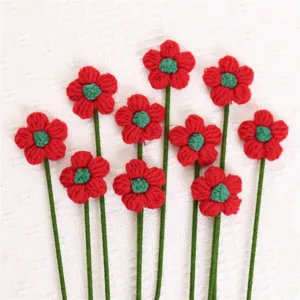 Handmade red knitted flowers with green stems for Christmas holiday decoration bouquet
