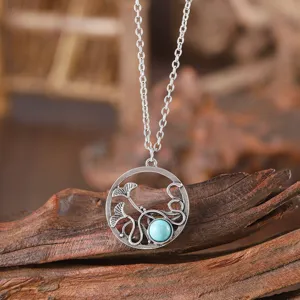 Detailed view of retro vintage alloy necklace with hollow plant pendant and turquoise stone.