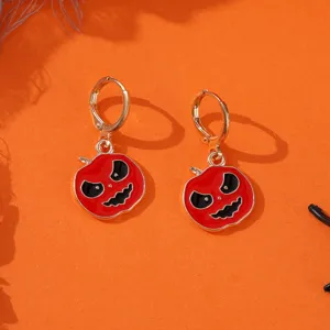 Nahaufnahme von Halloween Kürbis Ohrringen, rotes Emaille Kürbis Detail auf orangem Grund.