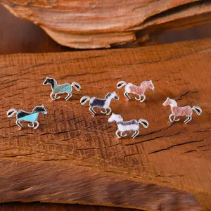 Vue en détail des boucles d'oreilles clous cheval mignon design alliage texture peluche.