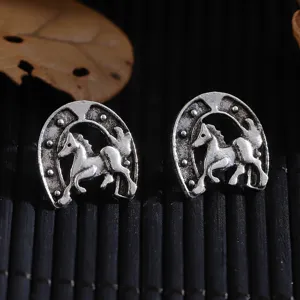 Detaillierte Nahaufnahme von Vintage Silber Hufeisen und galoppierenden Pferd Ohrsteckern.