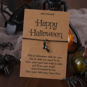 Halloween Wunscharmband mit schwarzem Fledermaus Anhänger auf Kraftpapierkarte Detail.