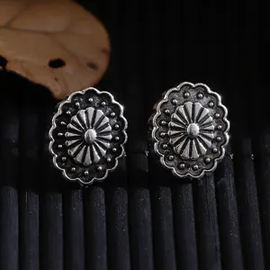 Nahaufnahme von Vintage Blumen Metall Ohrringen mit Retro Silber Finish und feinem Design.