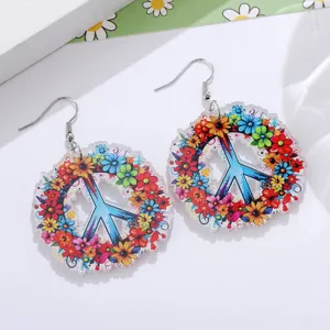 Primo piano di orecchini pendenti in acrilico con segno di pace floreale, gioiello boho.