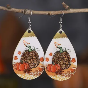 Detailaufnahme der herbstlichen Kürbis-Leopardenmuster PU-Leder-Ohrringe hängend am Ast