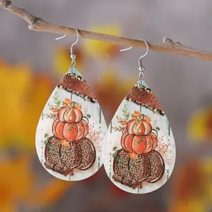 Nahaufnahme von tropfenförmigen Kunstleder-Ohrringen mit Herbst-Kürbis- und Leopardenmuster.
