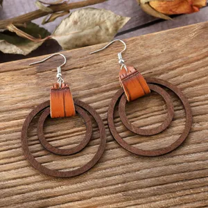 Primer plano detalle pendientes colgantes de madera y cuero bohemio encanto rústico.