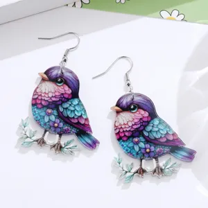 Detailed close-up of vibrant acrylic bird drop earrings with floral branch design and hooks.