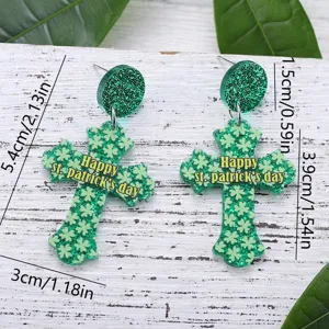 Groene glitter acryl kruis hangende oorbellen detailweergave met St. Patrick's dag klaver ontwerp.