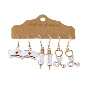 Set de pendientes colgantes esmaltados de enfermera con gorro, jeringa y estetoscopio.