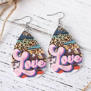 Primer plano muy detallado de pendientes con estampado de leopardo y la palabra Love.