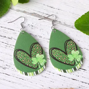 Dettaglio orecchini trifoglio San Patrizio, ecopelle verde cuore stampa gioielli festivi primo piano.