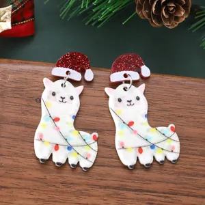 Primer plano de pendientes de acrílico de alpaca navideña con gorro y luces festivas.