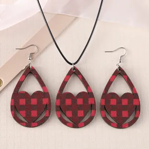 Close-up detail of the red and black plaid wooden heart earrings and necklace set.