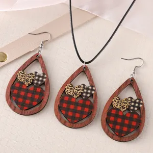 Close-up of wooden teardrop earrings necklace set featuring red buffalo plaid and leopard hearts.
