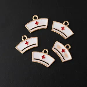 Close-up of nurse hat enamel charms, gold-plated alloy, red cross detail for DIY jewelry.
