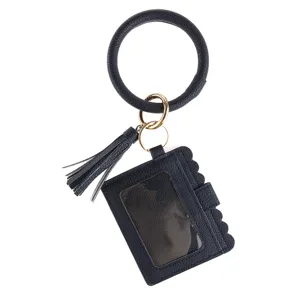 Dark blue PU leather wristlet keychain with card holder and tassel, close-up accessory detail.