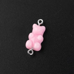 Pink resin gummy bear charm with metal loops, ideal for DIY jewelry making and crafts.