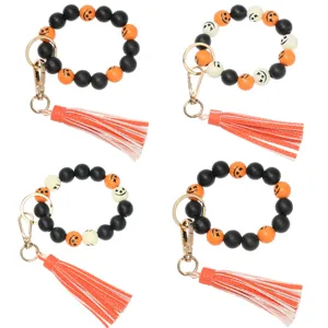 Halloween wooden bead wristlet keychain with colorful pumpkin beads and chic leather tassel.