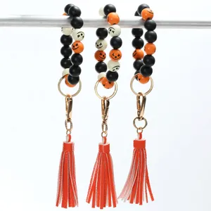 Halloween beaded wristlet keychain with leather tassel, orange and black wood beads.