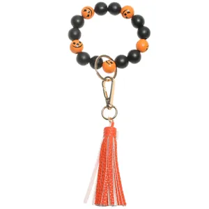 Halloween wooden bead keychain detail with orange leather tassel and cute pumpkin charms.