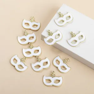 Detailed view of white masquerade mask charms with gold rims, perfect for DIY jewelry making.