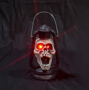 Primo piano della lanterna teschio di Halloween portatile con occhi LED rossi luminosi per festa.