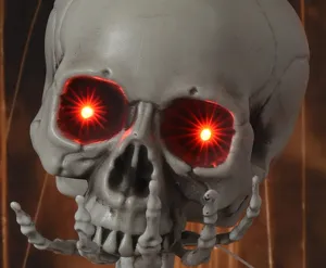 Halloween simulierter leuchtender Totenkopf Requisite mit roten LED Augen und Knochen.