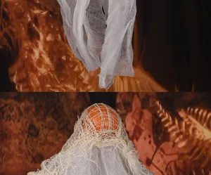 Dettaglio della decorazione fantasma di Halloween con tessuto di gauze e testa arancione.