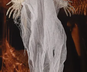 Primo piano della decorazione di Halloween fantasma sospeso con mani di scheletro.