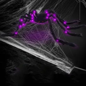 Giant Halloween plush spider with purple LED lights and red eyes for spooky outdoor party decor.