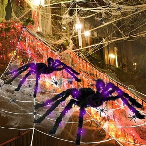 Detailed view of large glowing plush Halloween spiders with purple lights and creepy red eyes.
