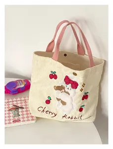 Close-up of cute corduroy tote bag detail featuring sweet rabbit embroidery and pink straps.