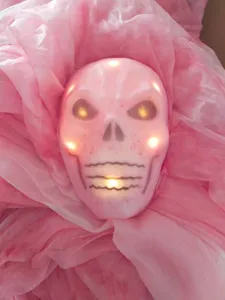 Gros plan détaillé d'un masque de crâne lumineux rose pour les thèmes de fête d'Halloween.