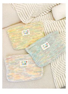 Knit plush cosmetic pouch detail, colorful soft textured fabric clutch bag storage.