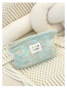 Close-up detail of the pastel multi-color knitted plush cosmetic pouch texture view.