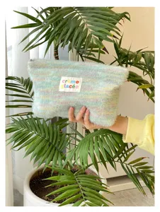 Fuzzy knit cosmetic pouch with pastel stripes, portable makeup bag and cute clutch for women.