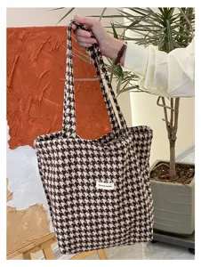 Detail view of a stylish houndstooth tote bag in soft wool fabric, ideal for autumn.