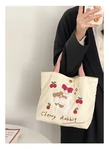 Close-up detail of the cute corduroy tote bag featuring embroidered rabbit and cherry patterns.