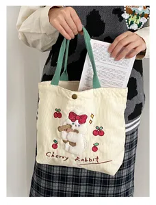 Cute corduroy handbag featuring a fluffy plush bunny and bear design with green straps for women.