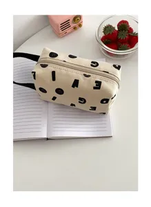 Détail de la trousse en toile beige avec des imprimés de lettres noires sur un cahier.