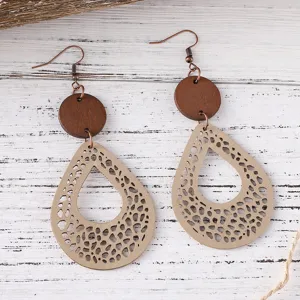 Vista de cerca detallada de pendientes colgantes bohemios de madera y cuero calado.