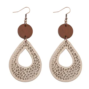 Vista detallada pendientes colgantes boho de madera y cuero con intrincados patrones calados.