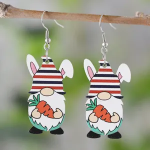 Nahaufnahme von Osterhase Gnom Holzohrringen am Zweig hängend, festlicher Osterschmuck.
