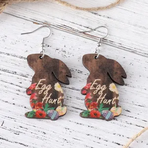 Detailed shot of wooden Easter bunny earrings with floral and egg print, drop dangle.