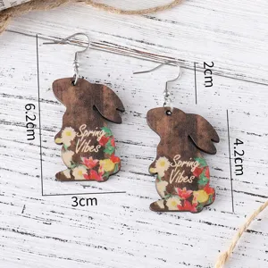 Detailed view of wooden rabbit drop earrings with floral spring vibes print and metal hooks.