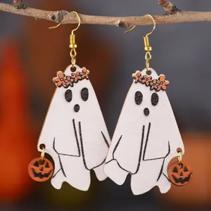 Nahaufnahme süßer hölzerner Geister Ohrringe mit Blumenkranz und Kürbis für Halloween.